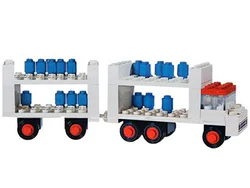 Truck carrying milk tankers with trailers.